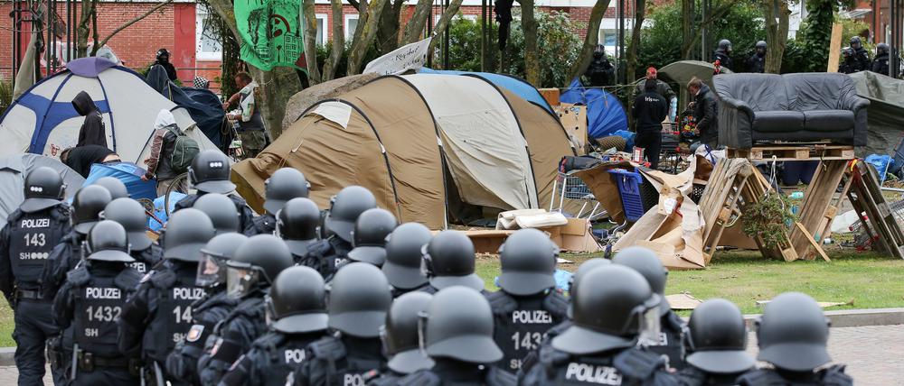 Behelmte Polizisten verfolgen die bislang freiwillige Räumung des Punk-Protestcamps in Westerland auf Sylt im Jahr 2022.