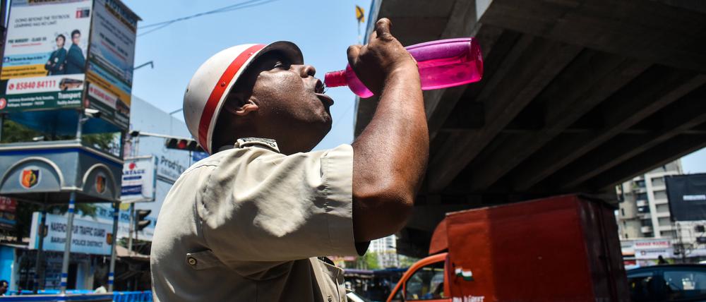 Ein Polizeibeamter aus Westbengalen trinkt während der Hitzewelle in Kolkata, Indien, Wasser.