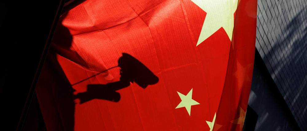 Eine Überwachungskamera hinter einer chinesischen Nationalflagge i Peking.
