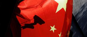 Eine Überwachungskamera hinter einer chinesischen Nationalflagge i Peking.