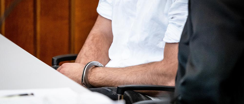 Der Angeklagte sitzt mit Handschellen in einem Gerichtssaal des Landgerichts Heilbronn auf seinem Platz. Der wegen Mordes angeklagte 21-jährige Mann verursachte mit einem Fahrzeug in der Heilbronner Innenstadt aufgrund von deutlich überhöhter Geschwindigkeit einen schweren Unfall, bei dem ein 42-jähriger Mann sein Leben verlor.