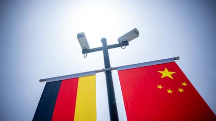 Überwachungskameras sind über der deutschen und der chinesischen Flagge vor der Tongji-Universität montiert.