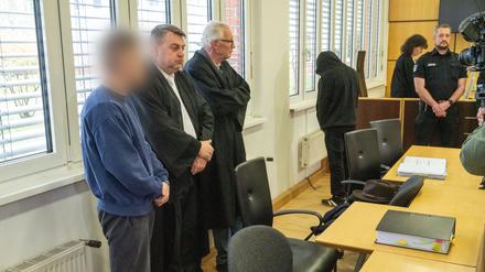 Die zwei Angeklagten (1. und 4. von links) stehen neben den zwei Verteidigern, Steffen Gerth (2.v.l) und Peter Hakert (3.v.l) vor Prozessbeginn im Sitzungssaal des Landgerichts Stralsund.