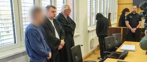 Die zwei Angeklagten (1. und 4. von links) stehen neben den zwei Verteidigern, Steffen Gerth (2.v.l) und Peter Hakert (3.v.l) vor Prozessbeginn im Sitzungssaal des Landgerichts Stralsund.