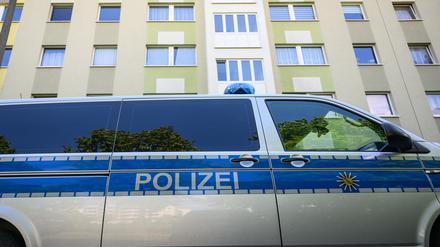 Ein Polizeiauto steht vor einem Wohnhaus.
