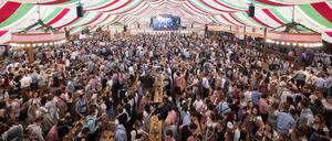 Besucher feiern in einem Festzelt des Stuttgarter Frühlingsfestes.