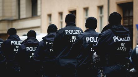 Polizisten einer Hundertschaft laufen durch den Regen. 