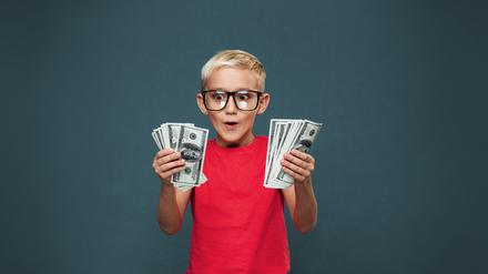 Kleiner Junge mit Geld in der Hand.