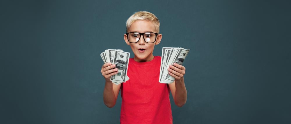 Kleiner Junge mit Geld in der Hand.