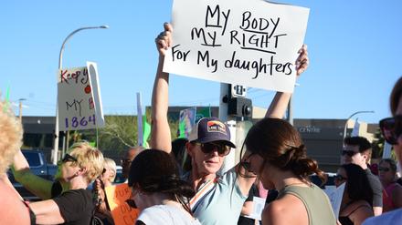 14.04.2024, USA, Scottsdale: Eine Demonstrantin hält ein Schild während einer Kundgebung gegen das Abtreibungsurteil. Hunderte von Menschen gingen am Sonntag auf die Straße, nachdem der Oberste Gerichtshof von Arizona am Dienstag ein fast vollständiges Abtreibungsverbot aus dem Jahr 1864 wieder in Kraft gesetzt hatte. Foto: Xuguang Sui/XinHua/dpa +++ dpa-Bildfunk +++