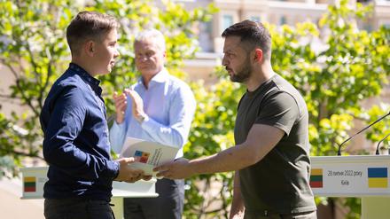 Präsident Selenskyj händigt einem 14-Jährigen einen Reisepass aus. 
