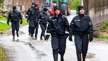 Polizisten und Polizistinnen gehen auf der Suche nach dem vermissten Arian aus Bremervörde über ein landwirtschaftliches Gelände.