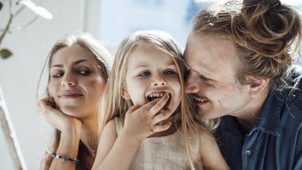 Zwei mittelalte Eltern mit ihrem mitteljungen Kind.