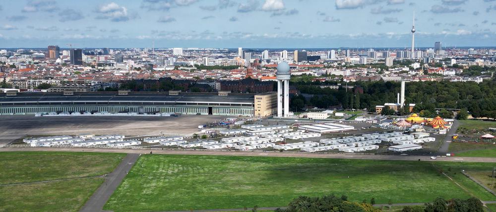 Die sogenannten Tempohomes, Wohncontainer für Geflüchtete, stehen vor dem früheren Hangar auf dem Tempelhofer Feld. Das riesige Flugfeld vom ehemaligen Flughafen Tempelhof ist vor dem Hintergrund der Wohnungsnot wieder im Gespräch. Der schwarz-rote Senat will einen internationalen städtebaulichen Wettbewerb zu einer möglichen Randbebauung der innerstädtischen Freifläche starten (Aufnahme mit einer Drohne).