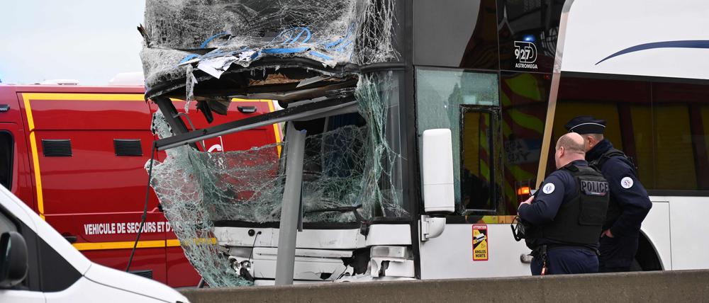 Französische Polizisten stehen an einem der verunfallten Busse.