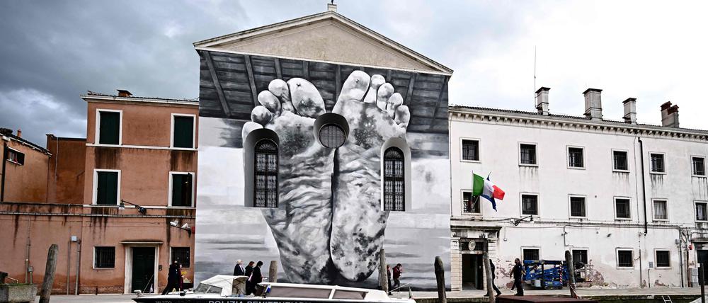 Ein Paar nackte Füße, schmutzig und verwundet, sind auf die Fassade der Kapelle des Frauengefängnisses in Venedig gemalt. Ein Werk des italienischen Künstlers Maurizio Cattelan.