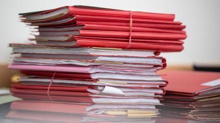 PRODUKTION - 27.03.2024, Berlin: Zahlreiche Aktenordner liegen auf einem Schreibtisch in einer Geschäftsstelle im Kriminalgericht Moabit. (zu dpa: «Aktenberge bei Staatsanwaltschaften in Berlin und Brandenburg wachsen») Foto: Monika Skolimowska/dpa +++ dpa-Bildfunk +++