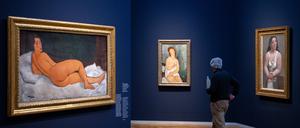 25.04.2024, Brandenburg, Potsdam: Ein Mann geht nach der Pressekonferenz zur Ausstellung «Modigliani. Moderne Blicke» im Museum Barberini an den Bildern (l-r) „Auf der Seite liegender Frauenakt (2017, Öl auf Leinwand) und „Junge Frau im Unterkleid, weiblicher Halbakt“ (1918, Öl auf Leinwand) von Amedeo Modigliani sowie „Sitzende Frau im Hemd“ (1921, Öl auf Leinwand) von Pablo Picasso vorbei. 