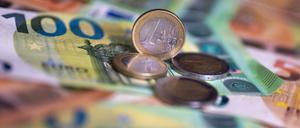 Geldscheine mit dem Wert von 100 und 50 Euro und Münzen liegen auf einem Tisch.