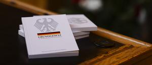 Vier Bücher mit dem Grundgesetz liegen während einer Einbürgerungsfeier auf einem Tisch im Ratssaal des Kieler Rathauses. 
