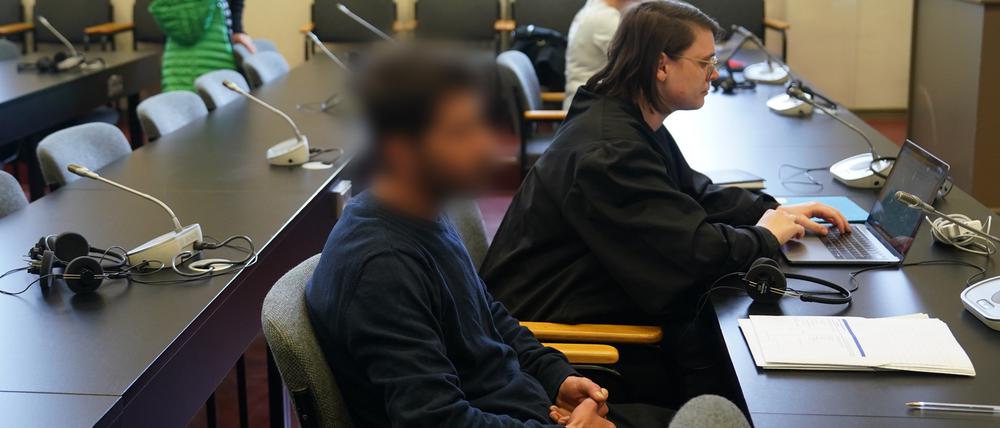 Der Angeklagte (vorne) sitzt zu Beginn des Prozesses wegen Geiselnahme, Entziehung Minderjähriger, vorsätzlicher Körperverletzung und Waffendelikten im Sitzungssaal im Strafjustizgebäude. 