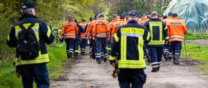 Einsatzkräfte der Feuerwehr gehen auf der Suche nach Arian eine Straße im Landkreis Stade entlang. 