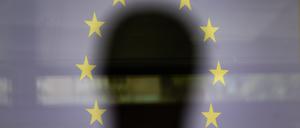 Eine Silhouette ist vor einer Projektion der EU-Flagge zu sehen (Symbolbild).