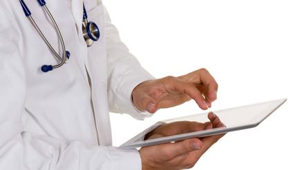 Ein junger Arzt mit Stethoskop und Tablet.