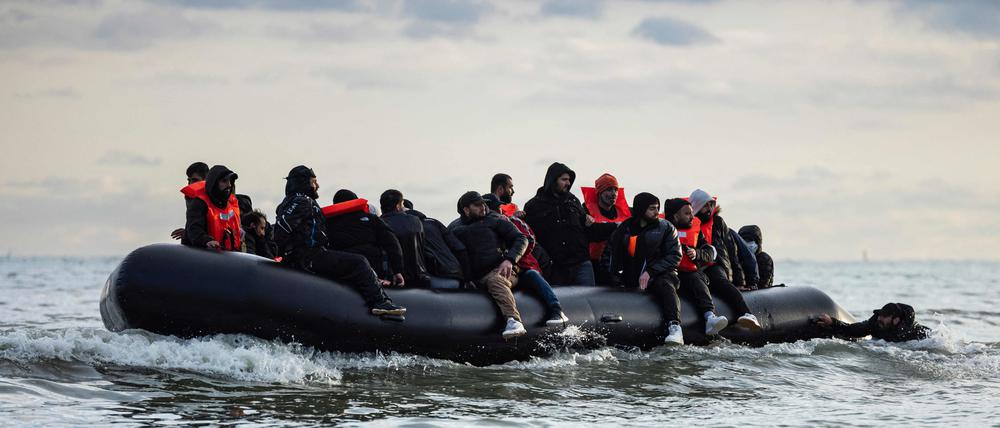 Migranten sitzten auf einem Schlauchboot und versuchen, den Ärmelkanal zu überqueren.