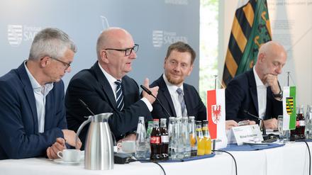 30.04.2024, Sachsen, Boxberg: Florian Engels (l-r), Regierungssprecher, Dietmar Woidke (SPD), Ministerpräsident von Brandenburg, Michael Kretschmer (CDU), Ministerpräsident von Sachsen, und Ralph Schreiber, Regierungssprecher, nehmen nach einer bilateralen Kabinettssitzung im Kraftwerk Boxberg an einer Pressekonferenz teil. Themen sind unter anderem die Strukturentwicklung in der Lausitz, die Zusammenarbeit mit Polen und das Wolfsmanagement. Foto: Sebastian Kahnert/dpa +++ dpa-Bildfunk +++