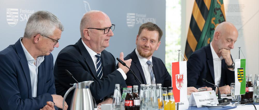 30.04.2024, Sachsen, Boxberg: Florian Engels (l-r), Regierungssprecher, Dietmar Woidke (SPD), Ministerpräsident von Brandenburg, Michael Kretschmer (CDU), Ministerpräsident von Sachsen, und Ralph Schreiber, Regierungssprecher, nehmen nach einer bilateralen Kabinettssitzung im Kraftwerk Boxberg an einer Pressekonferenz teil. Themen sind unter anderem die Strukturentwicklung in der Lausitz, die Zusammenarbeit mit Polen und das Wolfsmanagement. Foto: Sebastian Kahnert/dpa +++ dpa-Bildfunk +++
