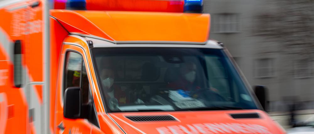 Ein Rettungswagen der Feuerwehr fährt auf einer Straße (Aufnahme mit Langzeitbelichtung).