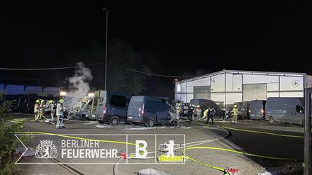 Einsatzkräfte der Berliner Feuerwehr löschen brennende Amazon-Transporter auf einem Grundstück im Ortsteil Wittenau.