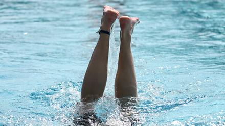 Eine Schwimmerin taucht ins Wasser ab. (Symbolbild)
