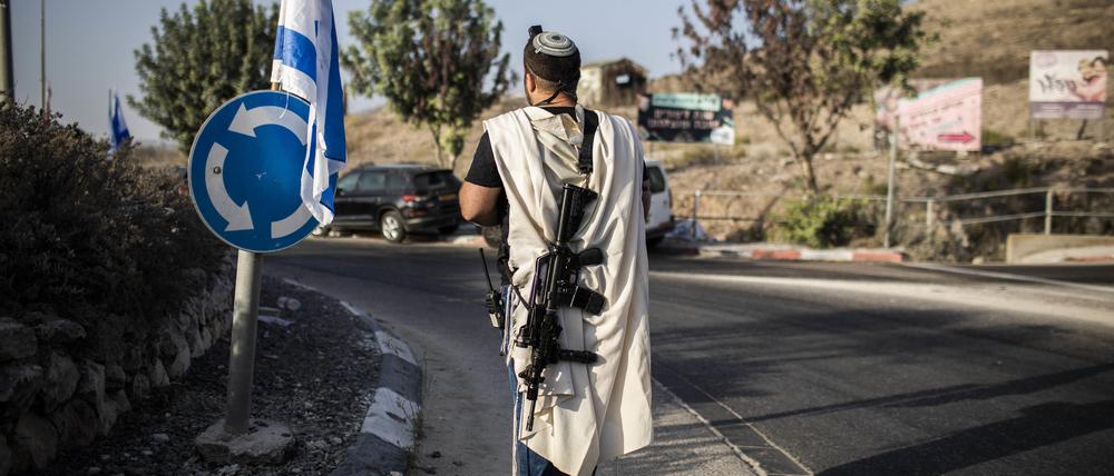 Ein israelischer Siedler trägt eine Waffe am Haupteingang der palästinensischen Stadt Nablus im besetzten Westjordanland.