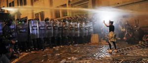 Eine Demonstrantin versucht, die Bereitschaftspolizei während eines Protestes der Opposition gegen das „russische Gesetz“ in der Nähe des Parlamentsgebäudes in Tiflis, Georgien, aufzuhalten.