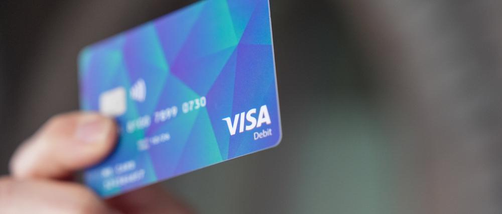 Ein Mann hält in Hamburg eine Bezahlkarte in der Hand.