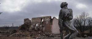 Ein Denkmal aus der Sowjetzeit, das den Soldaten des Zweiten Weltkriegs gewidmet ist, steht vor einem zerstörten Kulturhaus in der Nähe von Awdijiwka (Symbolbild).