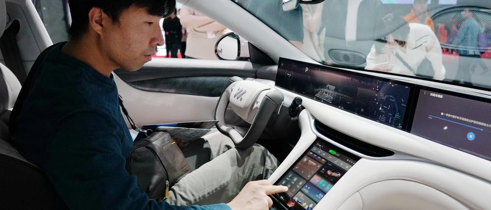 Ein Besucher sitzt im neuen Energiefahrzeugmodell von IM Motors auf der Internationalen Automobilausstellung 2024.