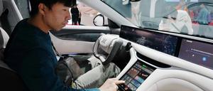 Ein Besucher sitzt im neuen Energiefahrzeugmodell von IM Motors auf der Internationalen Automobilausstellung 2024. 