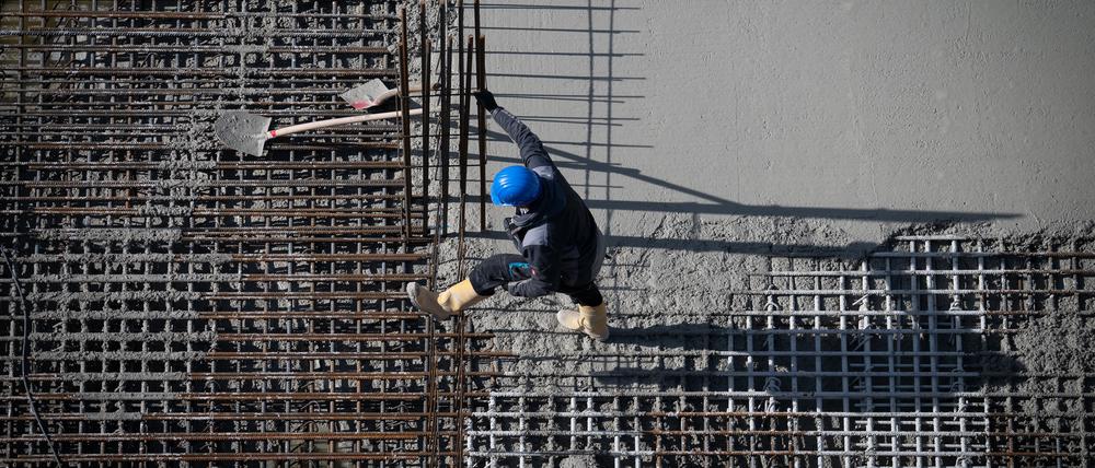 Berlin: Ein Arbeiter ist auf einer Baustelle am Alexanderplatz beschäftigt.