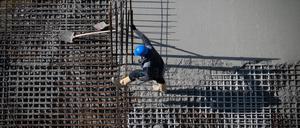 Berlin: Ein Arbeiter ist auf einer Baustelle am Alexanderplatz beschäftigt.