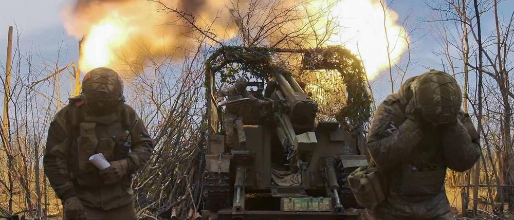 Russische Soldaten feuern an einem Geschütz.