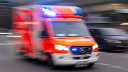 Ein Rettungswagen der Feuerwehr fährt mit Blaulicht zum Einsatz (Aufnahme mit Langzeitbelichtung).