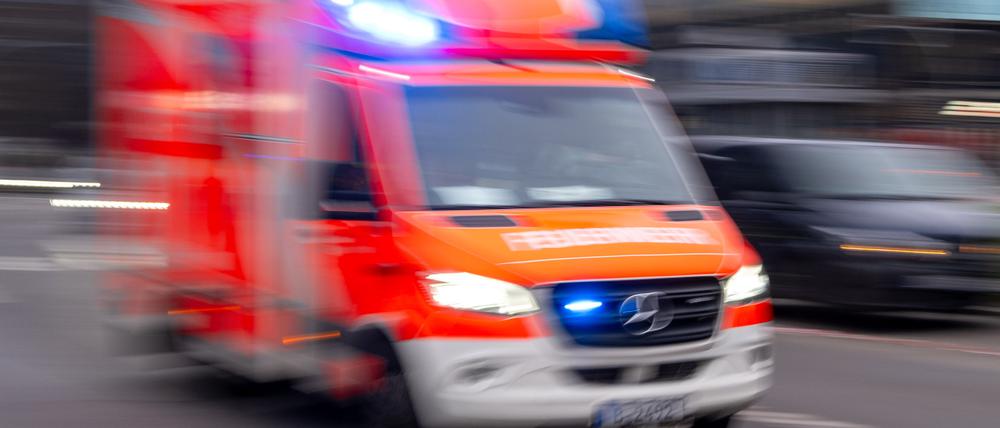 Ein Rettungswagen der Feuerwehr fährt mit Blaulicht zum Einsatz (Aufnahme mit Langzeitbelichtung).