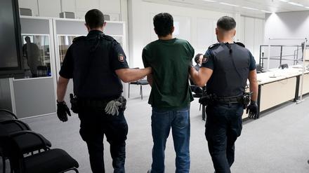 Der Angeklagte Ibrahim A. auf dem Weg zum Gerichtssaal im China Logistic Center, im Hintergrund sein Anwalt Björn Seelbach. 