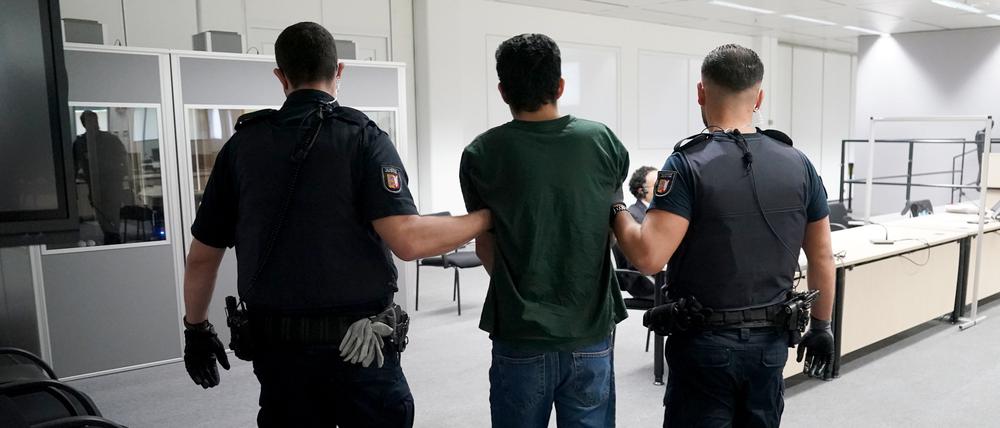 Der Angeklagte Ibrahim A. auf dem Weg zum Gerichtssaal im China Logistic Center, im Hintergrund sein Anwalt Björn Seelbach.