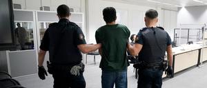 Der Angeklagte Ibrahim A. auf dem Weg zum Gerichtssaal im China Logistic Center, im Hintergrund sein Anwalt Björn Seelbach.