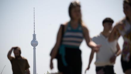 Menschen gehen bei Sonnenschein durch Berlin