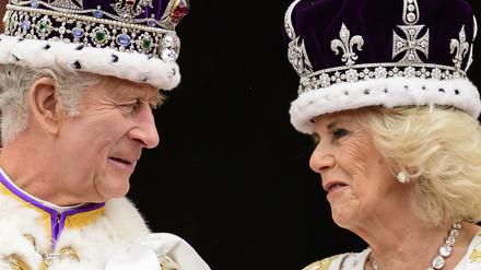 König Charles III. und Königin Camilla sehen sich an, als sie nach ihrer Krönung auf dem Balkon des Buckingham-Palastes stehen (Archivbild).
